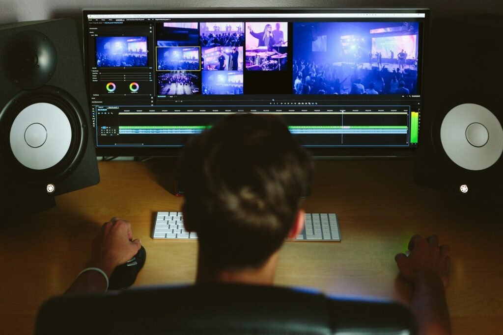 Editor working on a video at a desk with studio monitors